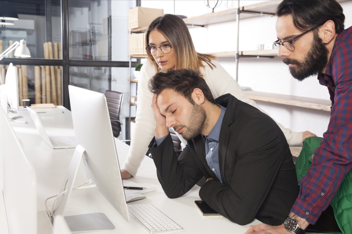 Work colleagues look disappointedly at a monitor due to bad experiences with external offshoring company