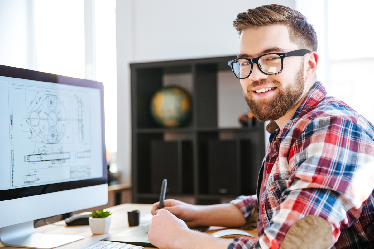 Engineer working on a blueprint with his computer